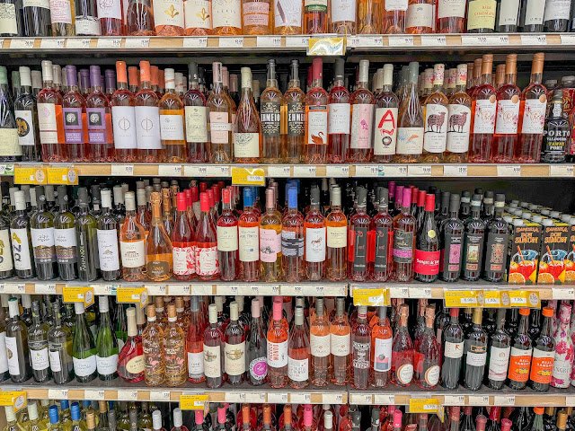 Wina czerwone na półce, w tym Agioritiko z regionu Nemea, znane z aksamitnych garbników i bogatego aromatu czerwonych owoców.